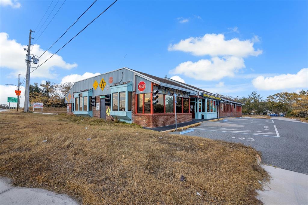 A single-story commercial building with a brick base, metal siding, and a parking lot — 210 STATE ROAD 60 W, LAKE WALES, FL