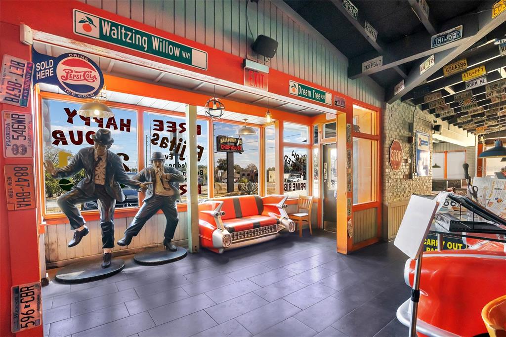 A room with tiled floors, a retro car-themed sofa, and statues of the Blues Brothers — 210 STATE ROAD 60 W, LAKE WALES, FL