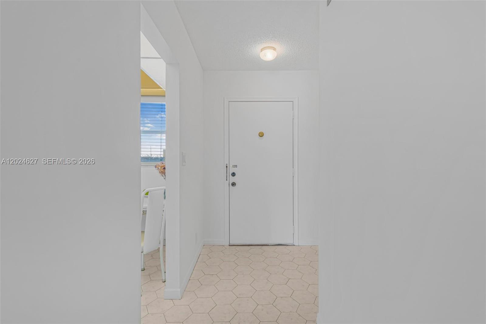 A white front door opens into a small entryway with light-colored hexagonal floor tiles — 500 NE 12th Ave # 407, Hallandale Beach FL 33009, HALLANDALE BEACH, FL
