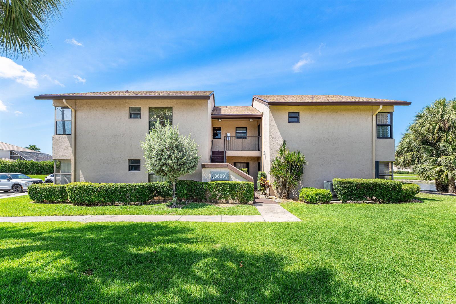 A two-story apartment building with beige stucco walls and a brown shingled roof — 8609 Boca Glades Boulevard W # A, Boca Raton FL 33434, BOCA RATON, FL