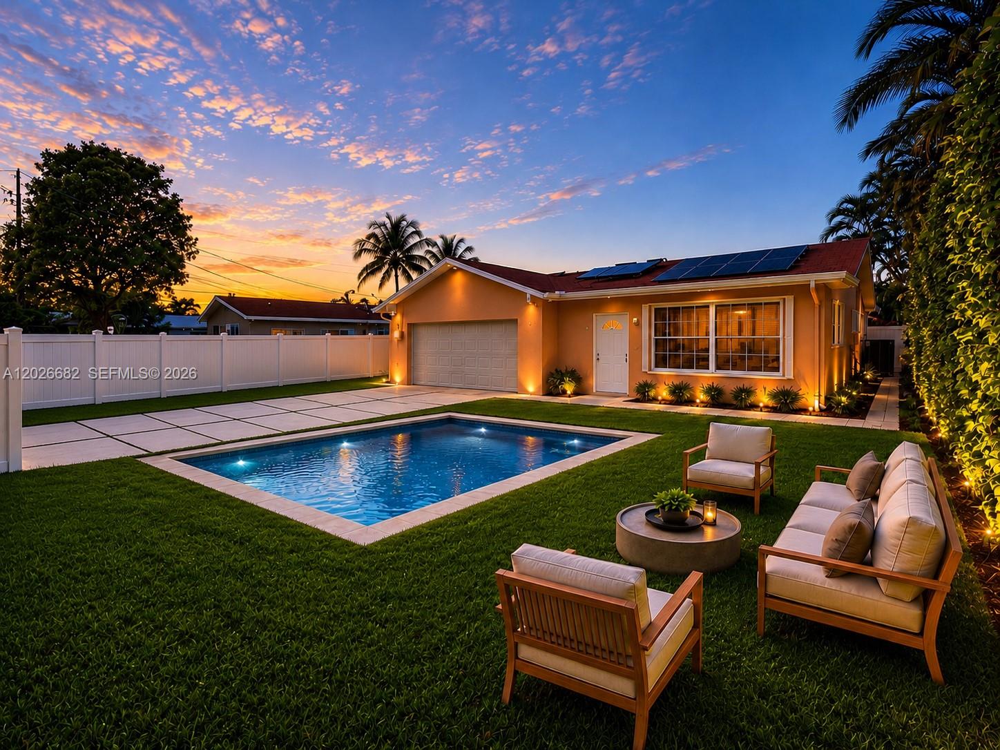A single-story house with a pool, patio furniture, and solar panels at sunset — 206 SE 3rd Pl, Dania Beach FL 33004, DANIA BEACH, FL