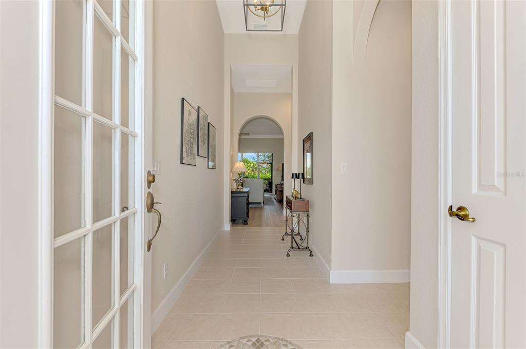 A bright entryway features tile flooring, arched doorways, and a view into the living area — 13384 GOLF POINTE DRIVE, PORT CHARLOTTE, FL