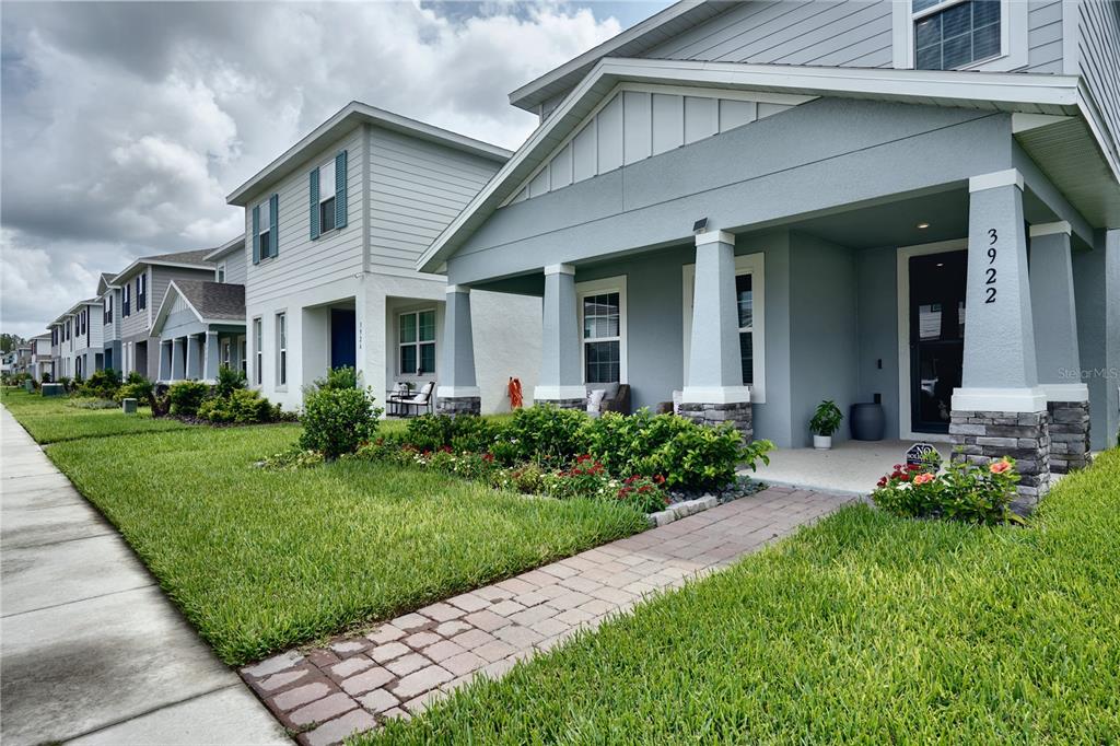 A row of light blue two-story houses with front porches and stone-based columns — 3922 GREAT SMOKEY WAY, APOPKA, FL