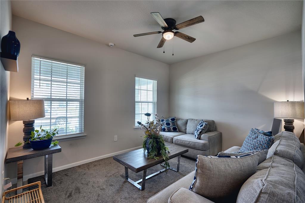 A living room features gray carpet, a sofa, a coffee table, and a ceiling fan — 3922 GREAT SMOKEY WAY, APOPKA, FL