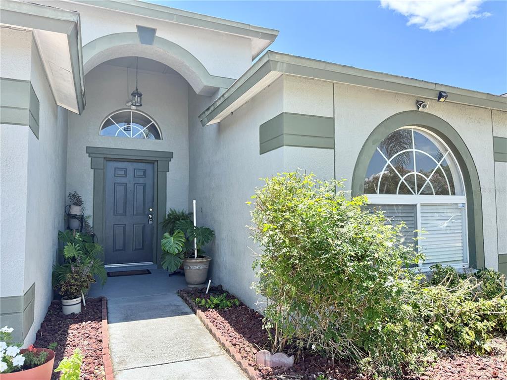A vintage-style convertible is parked in the driveway of a single-story suburban house — 30710 NICKERSON LOOP, WESLEY CHAPEL, FL