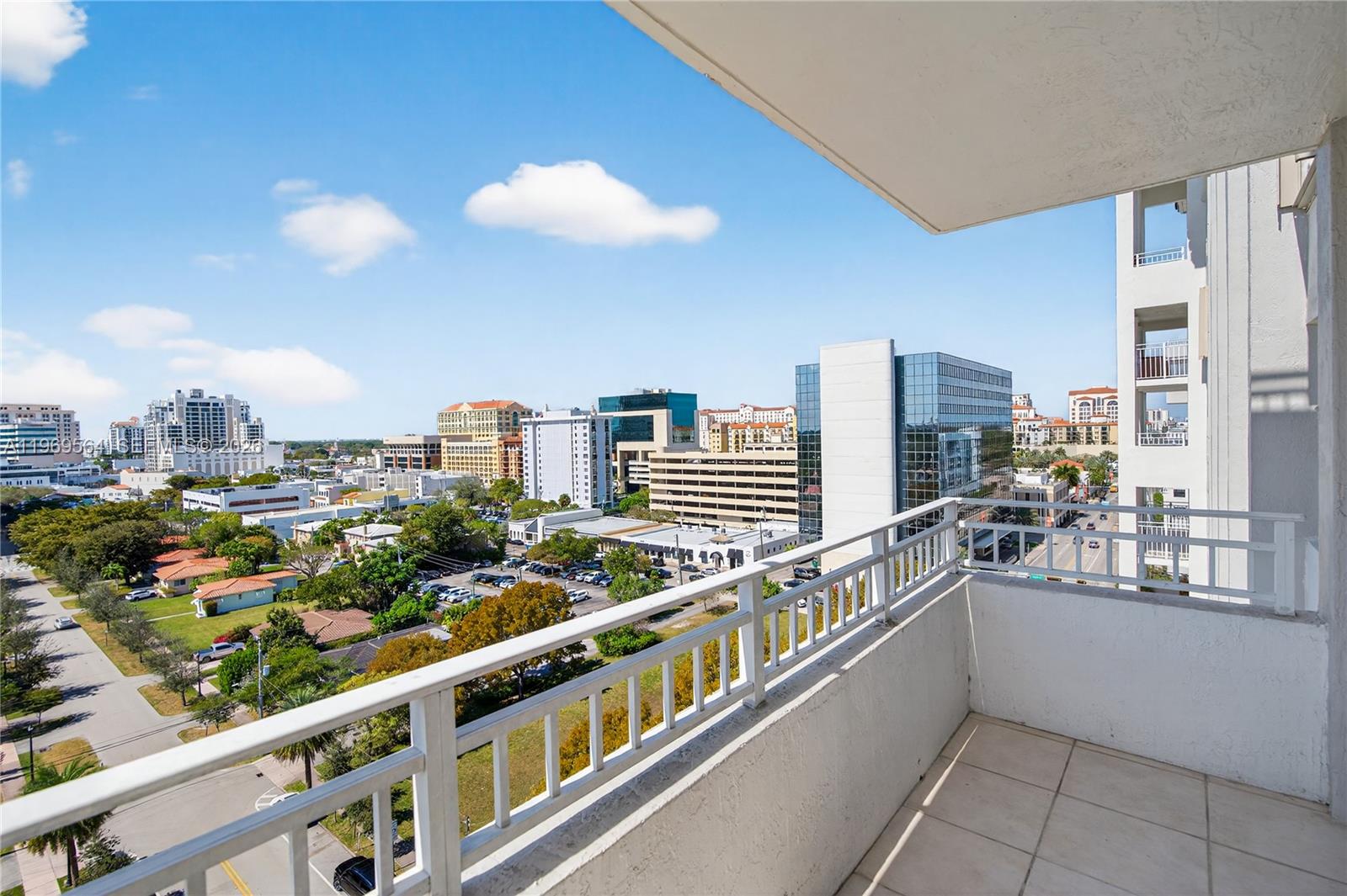 A living room features two white sofas, a glass coffee table, and a wall-mounted television — 2351 Douglas Rd # 1104, Miami FL 33145, MIAMI, FL