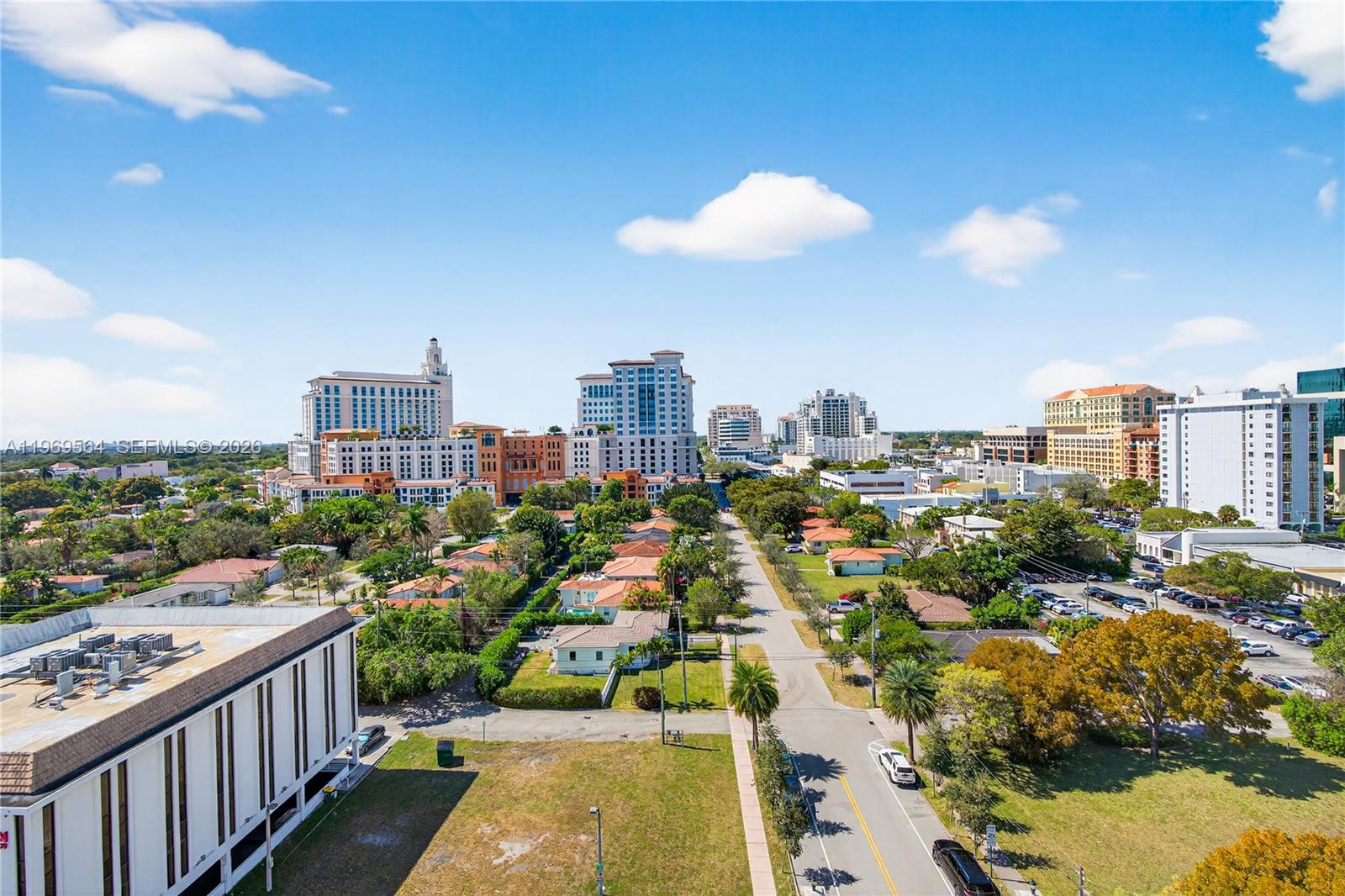 An open-concept living and dining area features tile flooring, a glass table, and city views — 2351 Douglas Rd # 1104, Miami FL 33145, MIAMI, FL