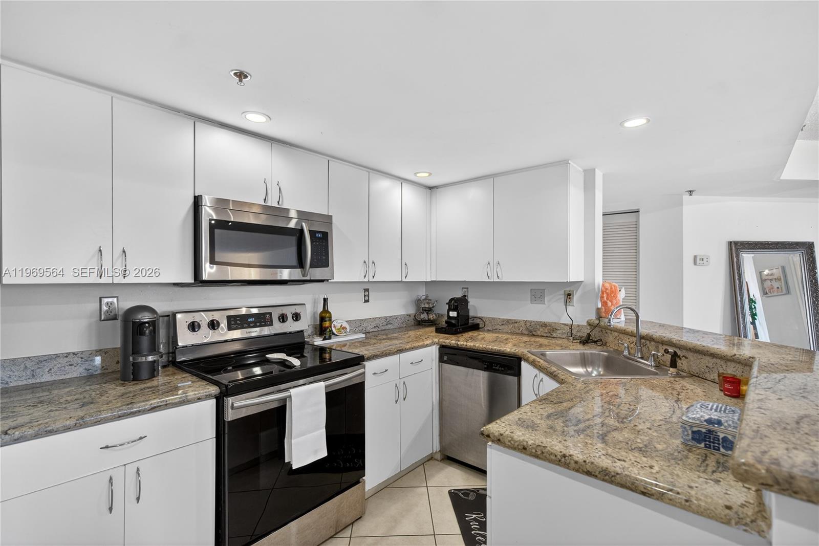 A high-rise balcony with a white metal railing overlooks a city skyline and streets — 2351 Douglas Rd # 1104, Miami FL 33145, MIAMI, FL