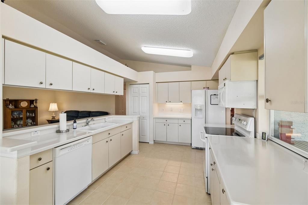 A kitchen with white cabinets, white countertops, a dishwasher, and a refrigerator — 18508 GRAND CLUB DRIVE, HUDSON, FL