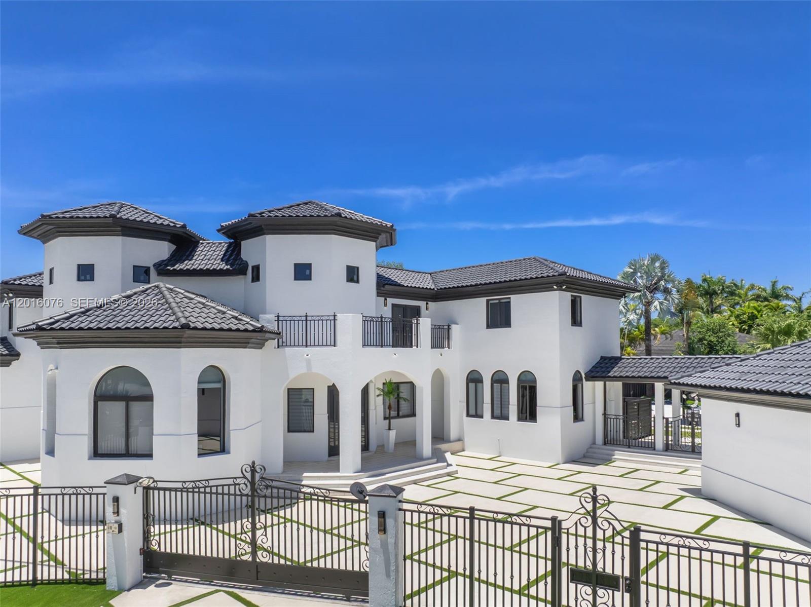 A white two-story house with a tiled roof and a gated paved driveway — 9881 SW 148th Ter, Miami FL 33176, MIAMI, FL