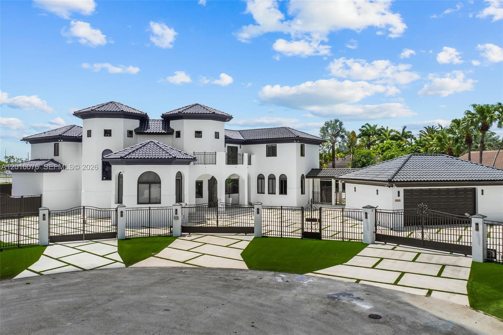 A large white Mediterranean-style house with a dark tile roof and gated driveway — 9881 SW 148th Ter, Miami FL 33176, MIAMI, FL