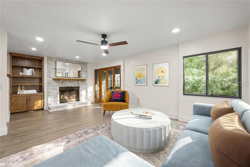 A living room features a brick fireplace, built-in shelving, a blue sofa, and wood flooring — 548 S OSCEOLA AVENUE, ORLANDO, FL
