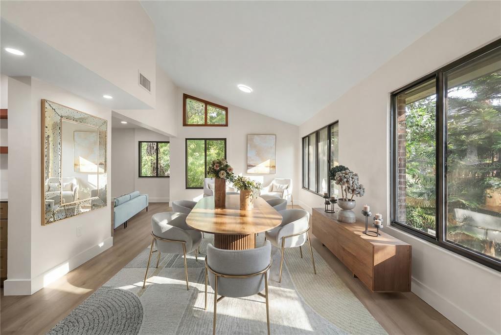A dining room features a wooden table, grey chairs, a rug, and large windows — 548 S OSCEOLA AVENUE, ORLANDO, FL