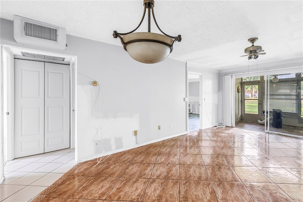 An interior view of a dining area with brown tile flooring and a hanging light fixture — 4774 LAKE BOULEVARD UNIT 9B, CLEARWATER, FL