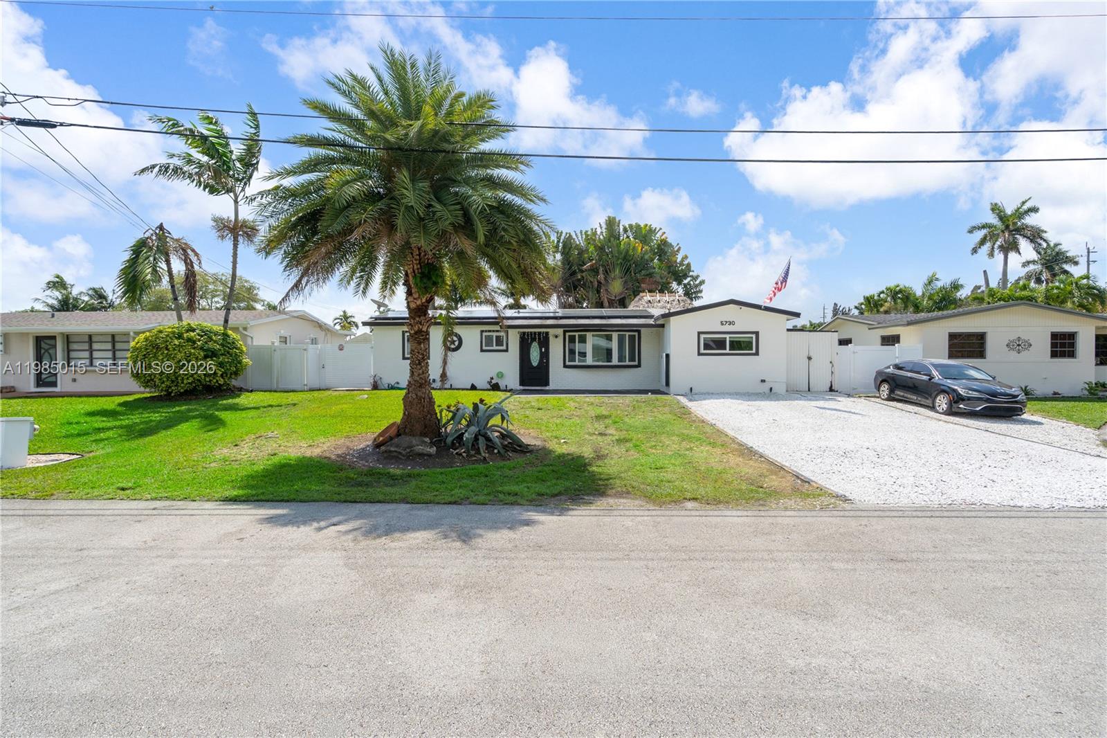 A single-story white house features a palm tree in the front yard and gravel driveway — 5730 SW 55th St, Davie FL 33314, DAVIE, FL