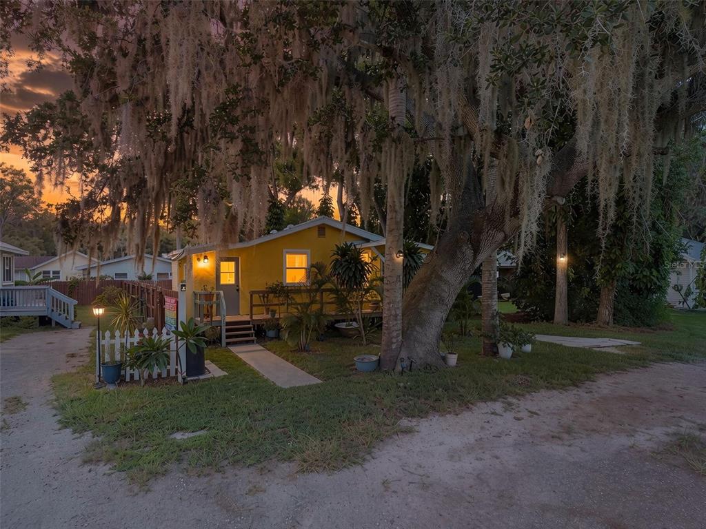An aerial view shows a residential neighborhood with houses, dense trees, and a nearby road — 5721 CASSON AVENUE, NEW PORT RICHEY, FL