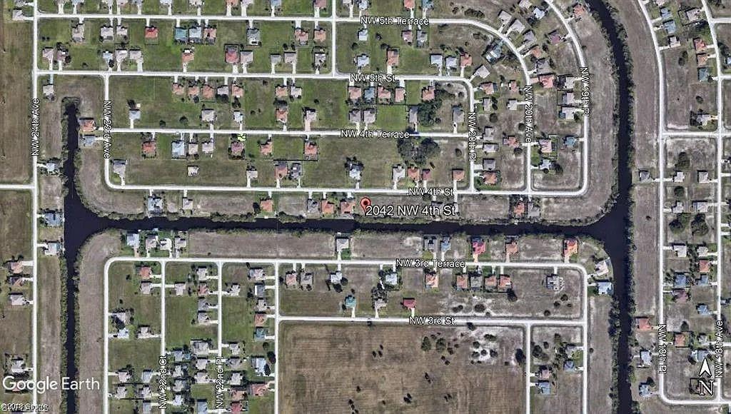 This is an aerial map view of a residential neighborhood with a canal — 2042 NW 4TH STREET, CAPE CORAL, FL