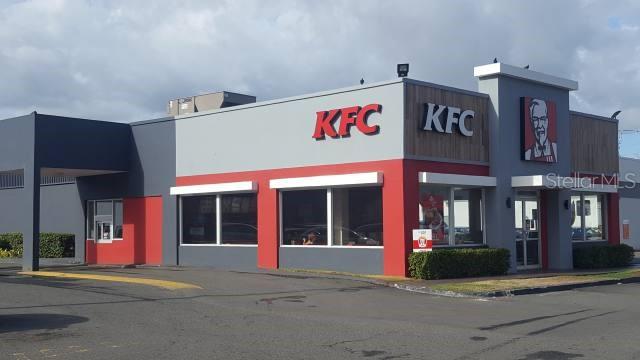 A modern KFC restaurant building with a drive-thru window and a gray and red exterior — 1 PR-1 INT. LEONICIO VELAZQUEZ, CAGUAS, PR
