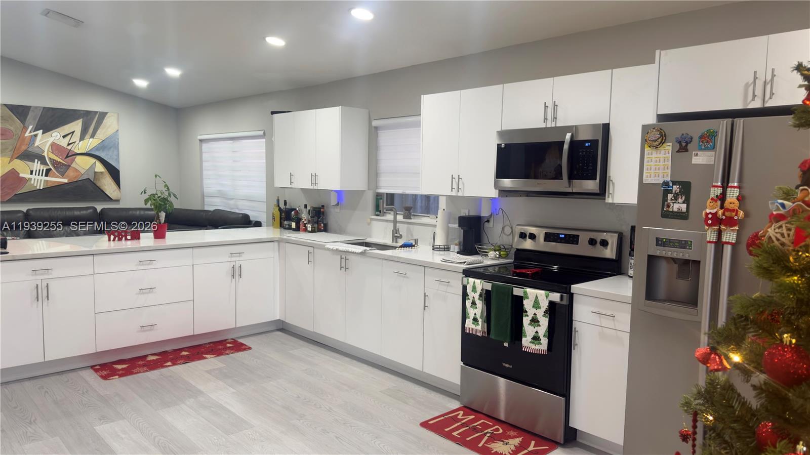 A modern kitchen features white cabinets, stainless steel appliances, and light-colored wood-look flooring — 2006 SE 14th Ct # 0, Homestead FL 33035, HOMESTEAD, FL
