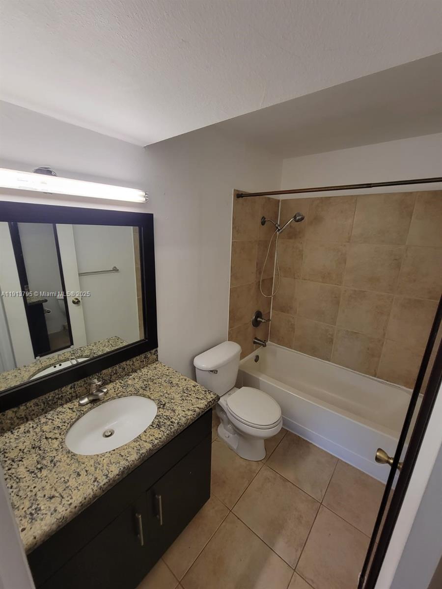 A bathroom features a granite vanity, a dark cabinet, a toilet, and a tiled tub — 3992 NW 87th Ave # 3992, Sunrise FL 33351, SUNRISE, FL