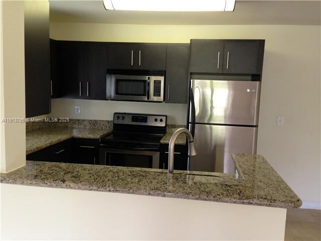 A kitchen features dark cabinets, granite countertops, and stainless steel appliances — 3992 NW 87th Ave # 3992, Sunrise FL 33351, SUNRISE, FL