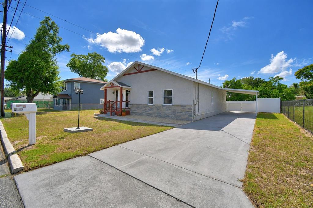 A single-story house with a concrete driveway, a carport, and a small front porch — 208 CENTER STREET, AUBURNDALE, FL