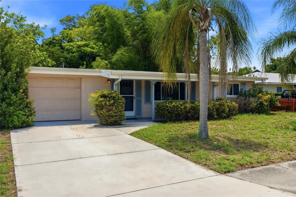 A single-story house with a beige exterior, a concrete driveway, and a palm tree — 5123 20TH STREET W, BRADENTON, FL