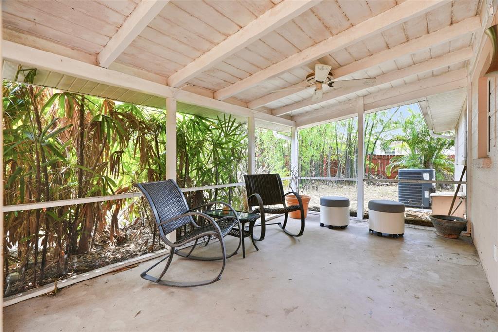 A screened-in porch features a concrete floor, two rocking chairs, and a ceiling fan — 5123 20TH STREET W, BRADENTON, FL