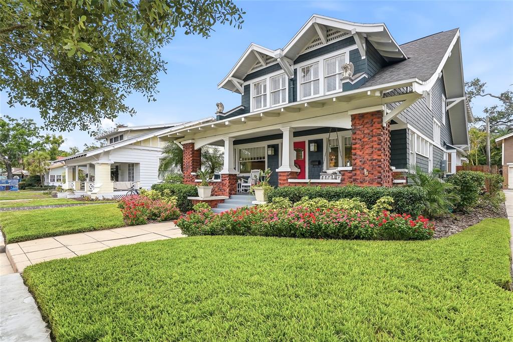 A covered front porch features a red door, a white rocking chair, and a hanging swing — 929 S OREGON AVENUE, TAMPA, FL