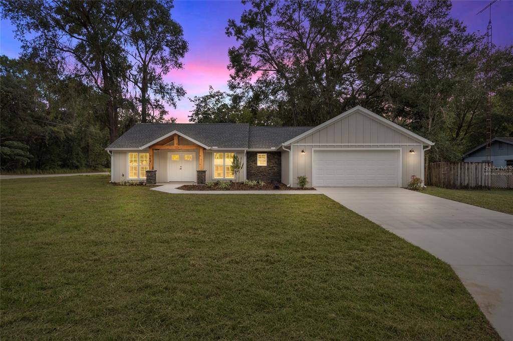 A single-story house with a light-colored exterior, stone accents, and a two-car garage — 7620 SW 78TH PLACE, OCALA, FL
