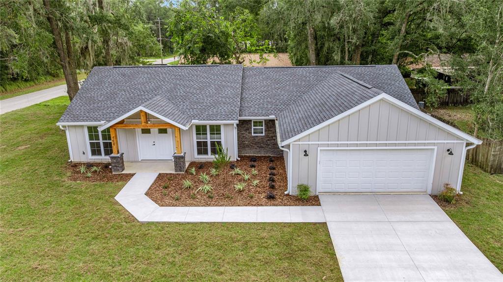 An aerial view of a single-story house with gray siding, a stone accent, and a garage — 7620 SW 78TH PLACE, OCALA, FL