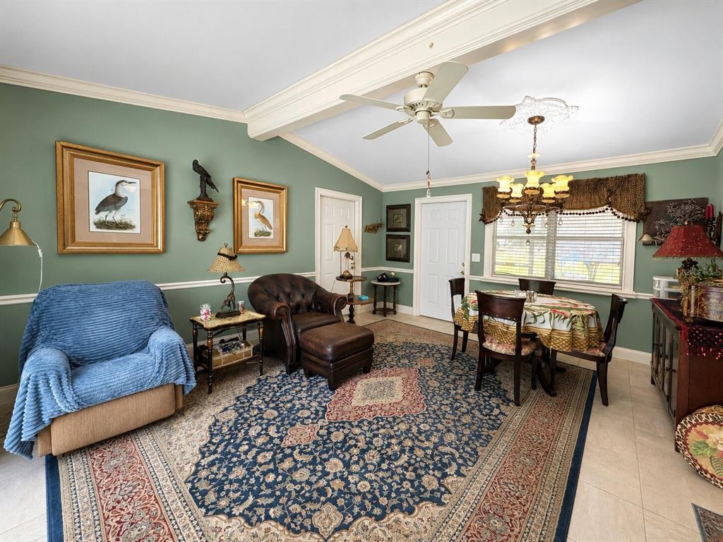 A living and dining area with sage green walls, a large rug, and a ceiling fan — 16363 SE 5TH STREET, SILVER SPRINGS, FL