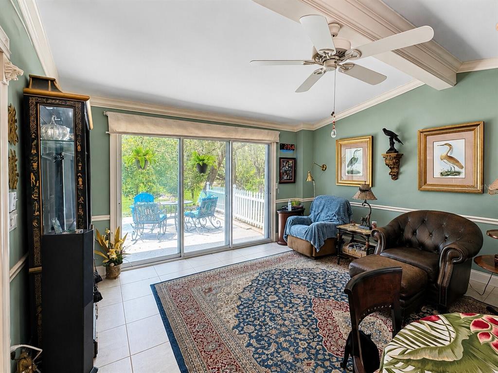 A living room with a ceiling fan, tiled floors, a large rug, and sliding glass doors — 16363 SE 5TH STREET, SILVER SPRINGS, FL