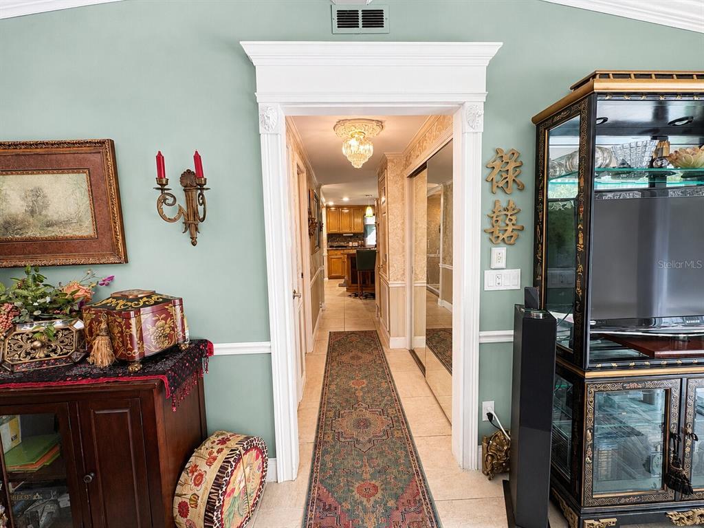 A hallway with a runner rug leads from a living area toward a kitchen — 16363 SE 5TH STREET, SILVER SPRINGS, FL