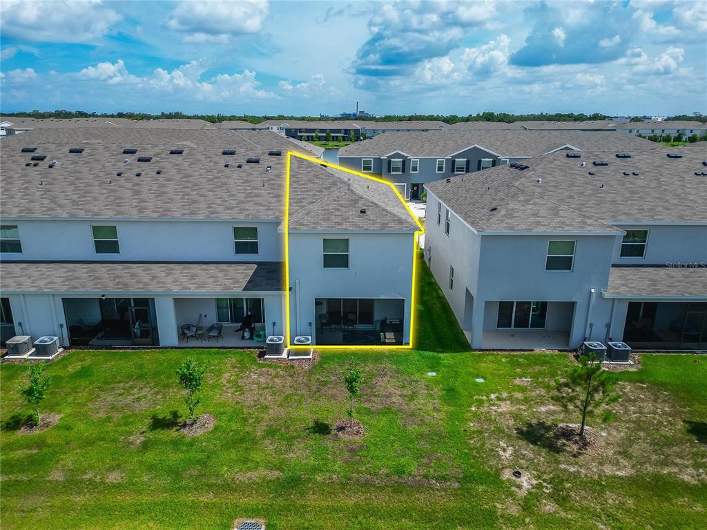 An aerial view shows the rear exterior of a two-story townhouse with a screened patio — 472 MANGROVE SHADE CIRCLE, APOLLO BEACH, FL