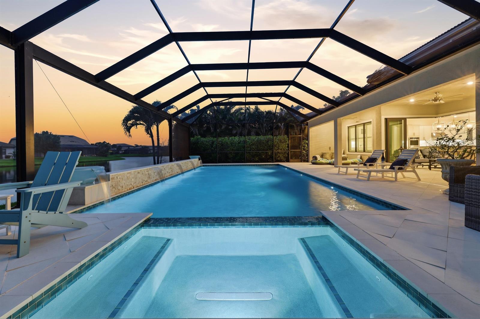 A screened-in patio features a swimming pool, a hot tub, and lounge chairs at sunset — 134 Indigo River Point, Jupiter FL 33478, JUPITER, FL