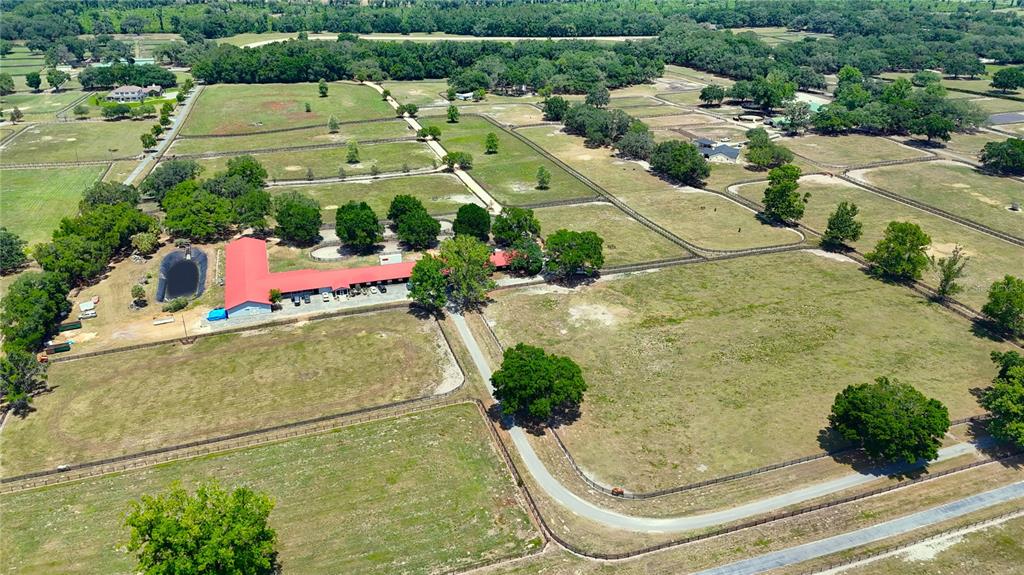 An aerial view of a large horse farm featuring a barn with a red roof — 6692 NW 150TH AVENUE, MORRISTON, FL