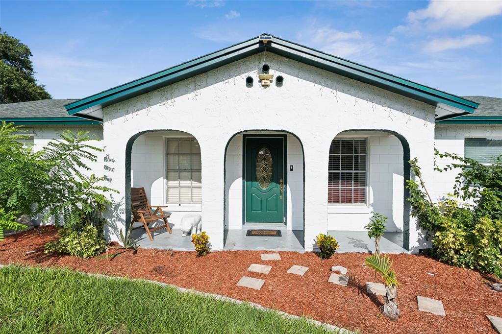 An open-concept kitchen and living area features a red leather sofa, breakfast bar, and appliances — 6694 RIVO ALTO AVENUE, ORLANDO, FL