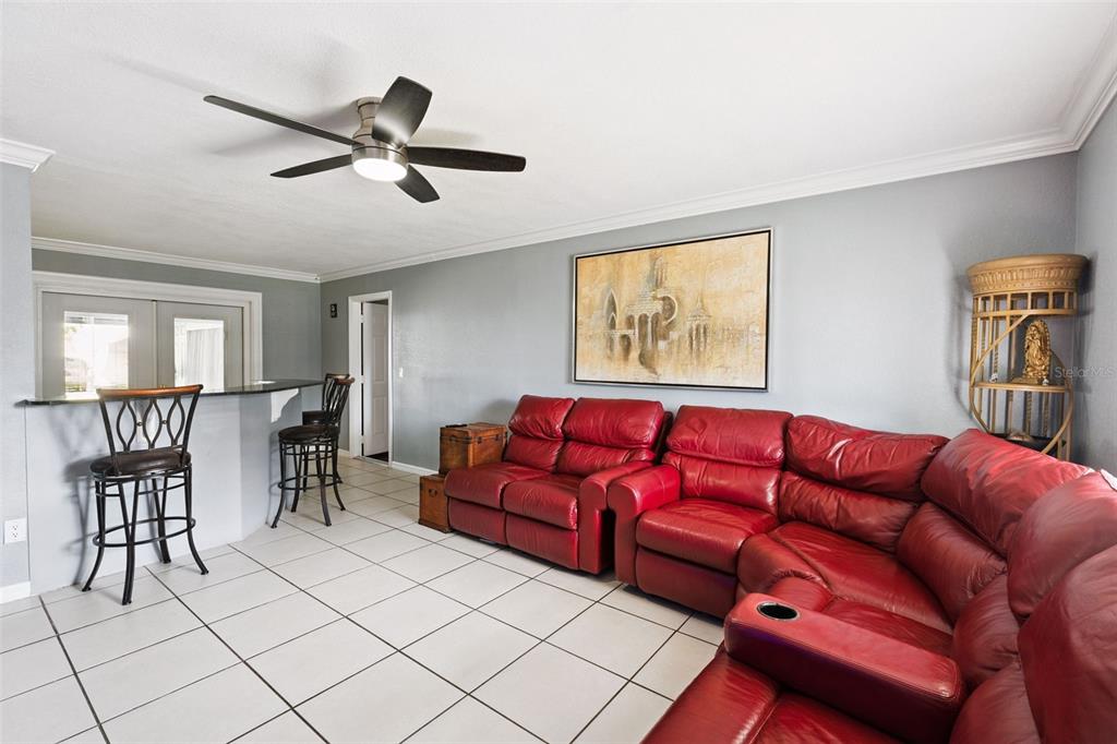 A kitchen features light wood cabinets, stainless steel appliances, and white tile flooring — 6694 RIVO ALTO AVENUE, ORLANDO, FL