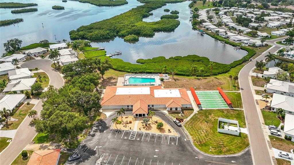 An aerial view shows a community clubhouse with a pool, sports court, and parking lot — 4001 CHINABERRY ROAD, BRADENTON, FL