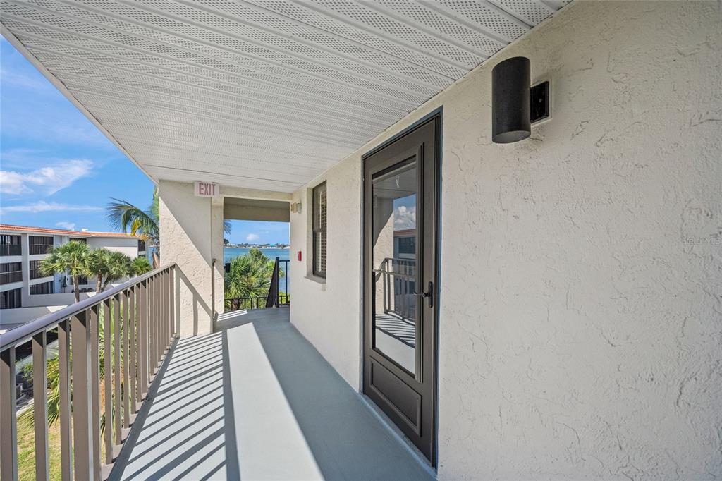 An outdoor balcony with a metal railing, a glass door, and a view of water — 1591 BEACH ROAD UNIT 401, ENGLEWOOD, FL