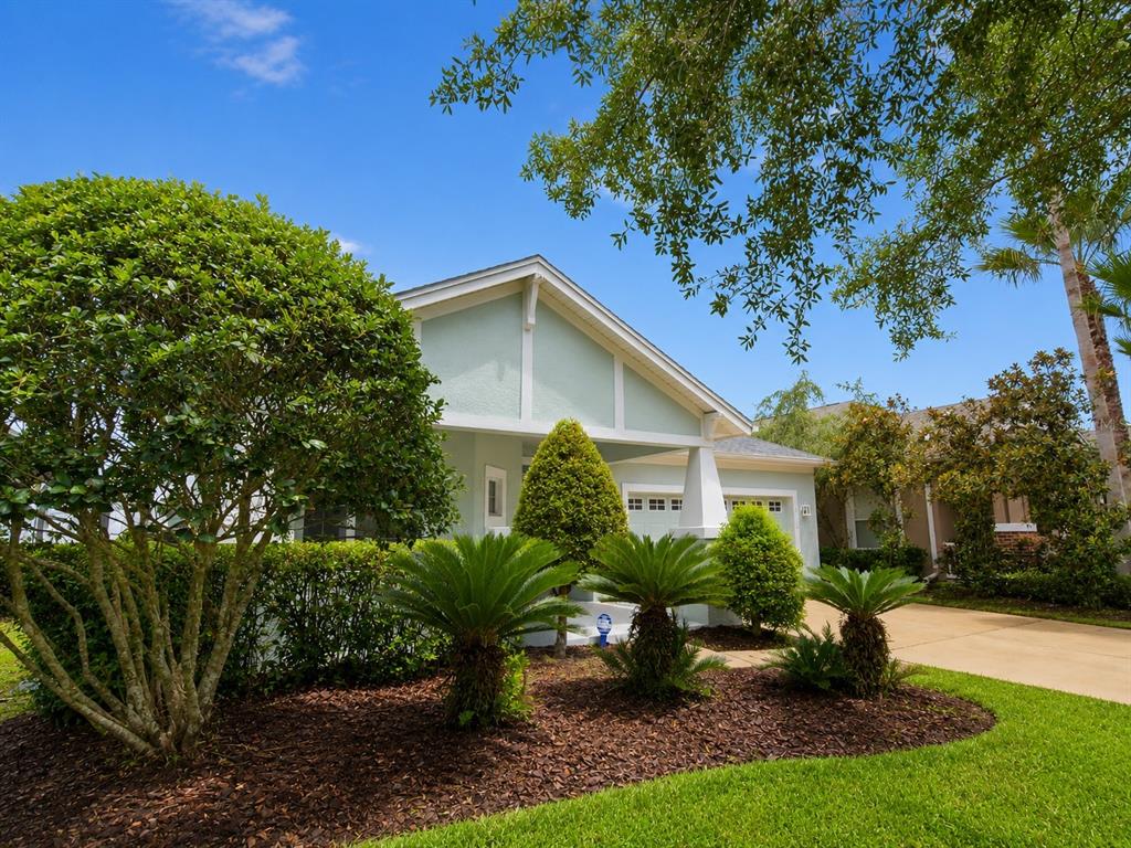 A light green house with a gabled roof, a front porch, and landscaped front yard — 8119 HAMPTON LAKE DRIVE, TAMPA, FL