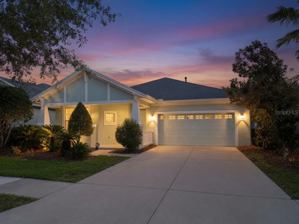 A light green single-story house with a two-car garage at dusk — 8119 HAMPTON LAKE DRIVE, TAMPA, FL