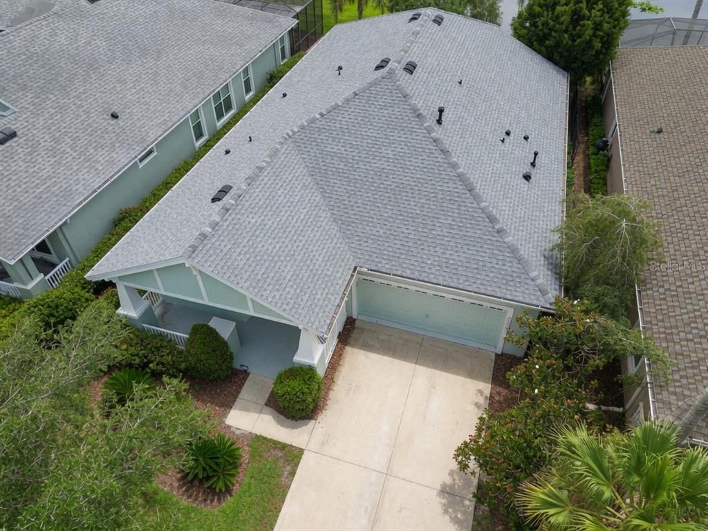 An aerial view shows a single-story house with a gray shingled roof and driveway — 8119 HAMPTON LAKE DRIVE, TAMPA, FL
