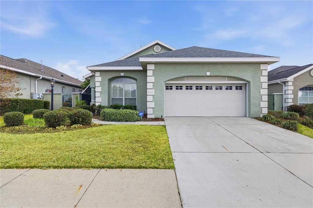 A single-story house with a light green stucco exterior, white trim, and a two-car garage — 4111 SW 30TH COURT, OCALA, FL