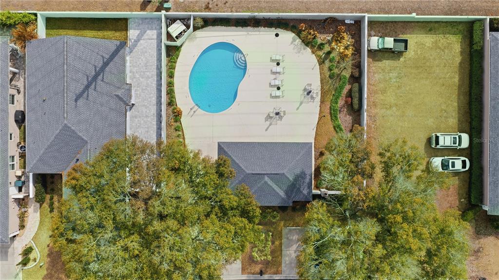 An aerial view shows a house with a pool, patio, and large trees in the yard — 4111 SW 30TH COURT, OCALA, FL
