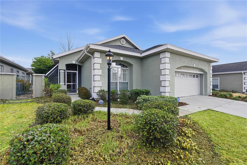 A single-story house with a green stucco exterior, a two-car garage, and a front lawn — 4111 SW 30TH COURT, OCALA, FL