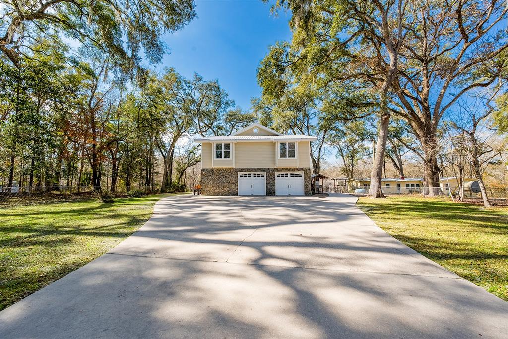 A two-story house with a stone base and two garage doors sits at the end of a driveway — 498 SW MANATEE TERRACE, FORT WHITE, FL