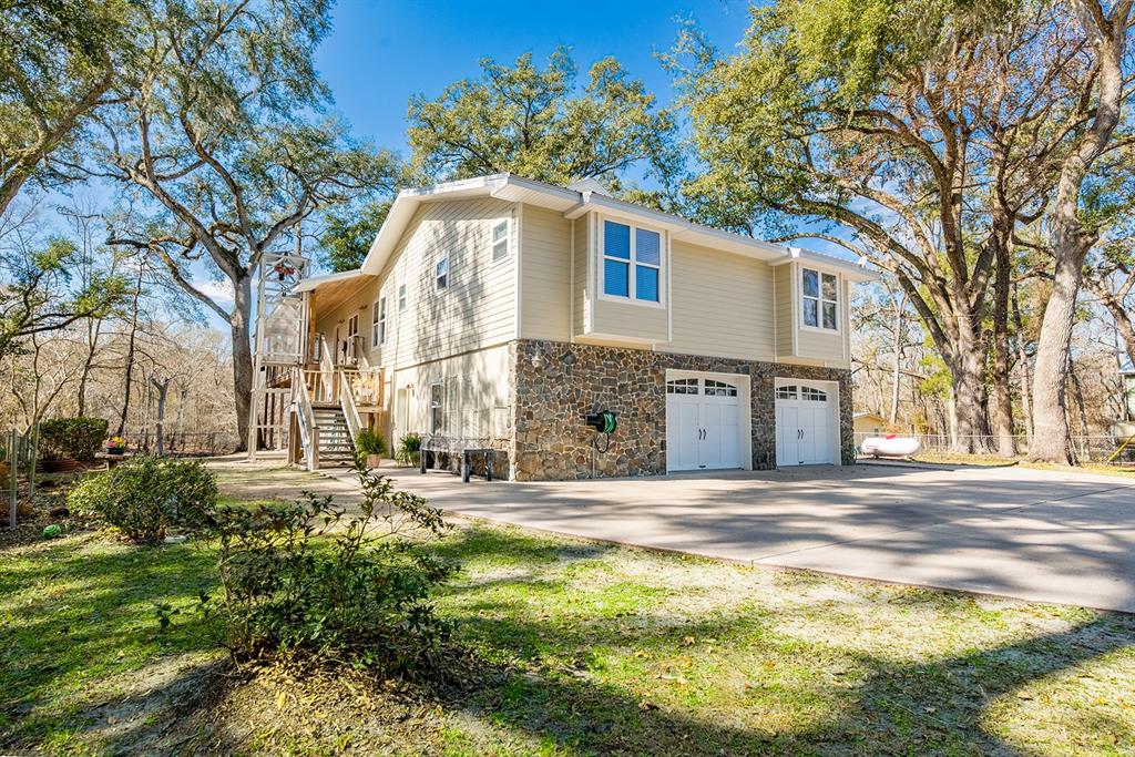 A two-story house with tan siding, a stone base, and a two-car garage — 498 SW MANATEE TERRACE, FORT WHITE, FL