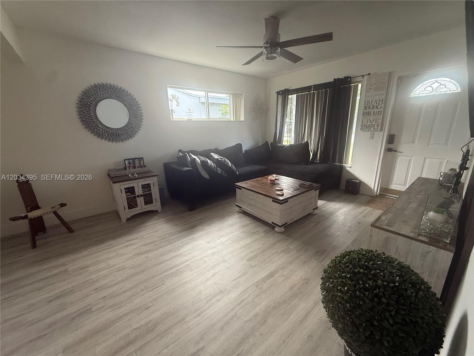A living room features a dark sectional sofa, a wooden coffee table, and light flooring — 2538 Coolidge St, Hollywood FL 33020, HOLLYWOOD, FL